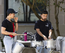 A percussion ensemble performs in an outdoor setting.
