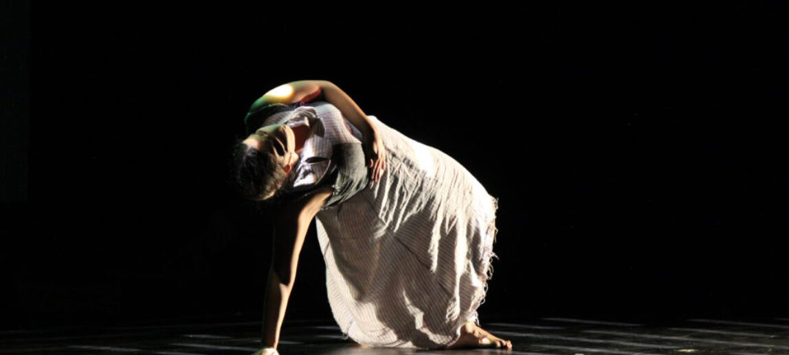 Performer in dance pose on stage