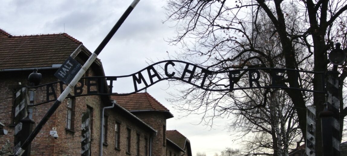 An outdoor gate with the words Auschwitz-Birkenau