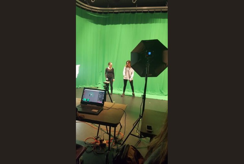 student instructing performer in front of a green screen