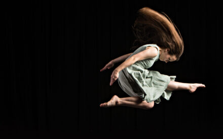 Dancer leaps with her hair flowing behind her