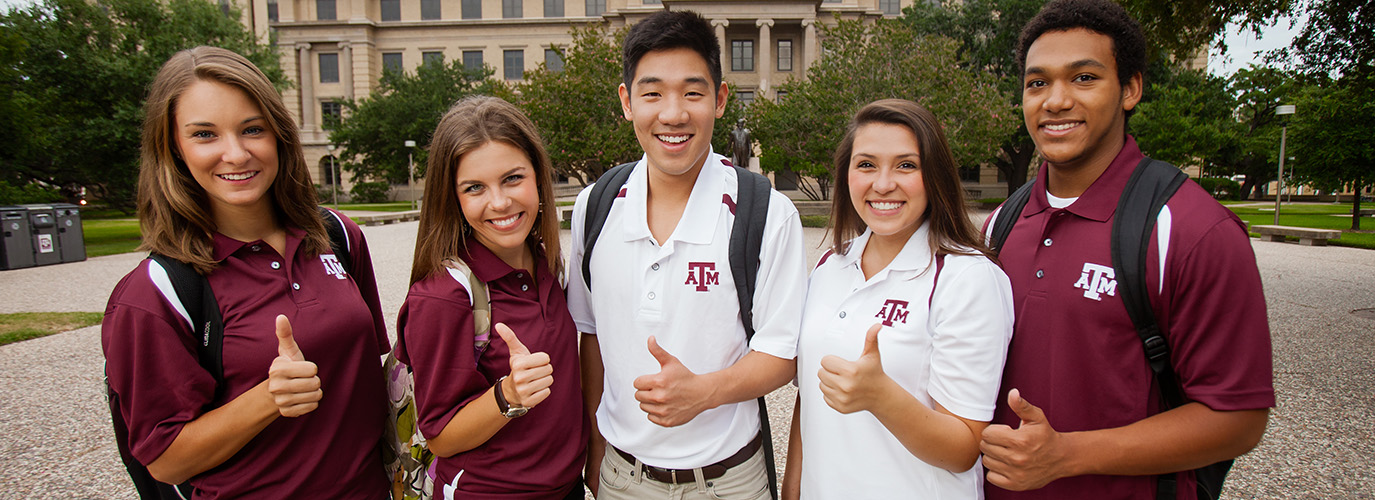 Five students give the Gig 'Em in front of the Academic Building