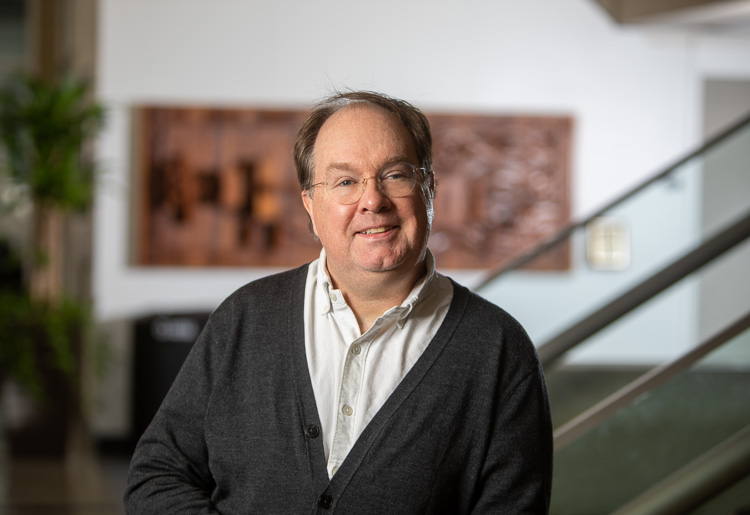 A university professor smiles for a portrait photo.