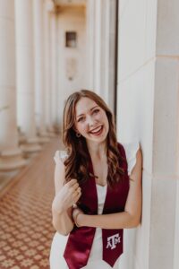 A portrait of a woman, Marissa Conway, with a graduation sash.