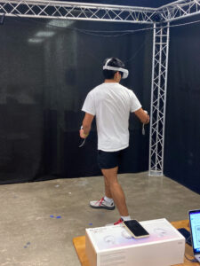 A young man wearing virtual reality goggles.