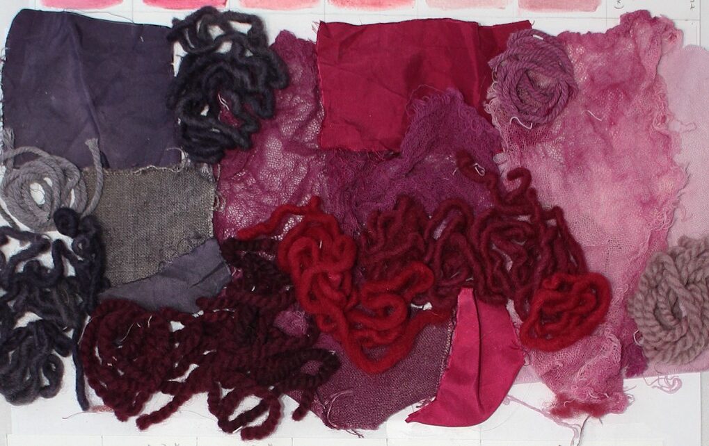 Several examples of textiles that have been dyed shades of red through working with cochineal insects