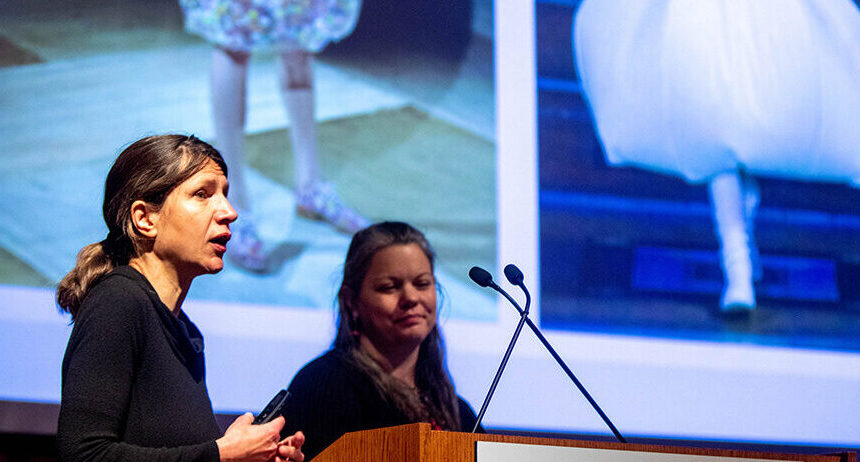 Two professors give a presentation at a podium.