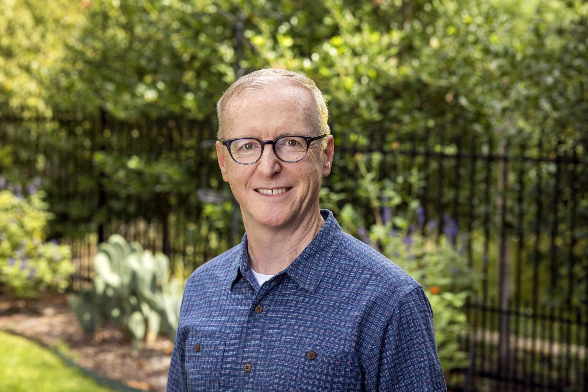 A portrait of a man in an outdoor garden setting