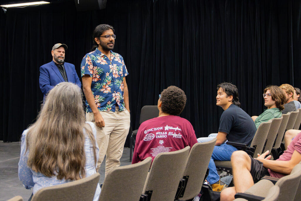 A man stands up to perform improv for the class