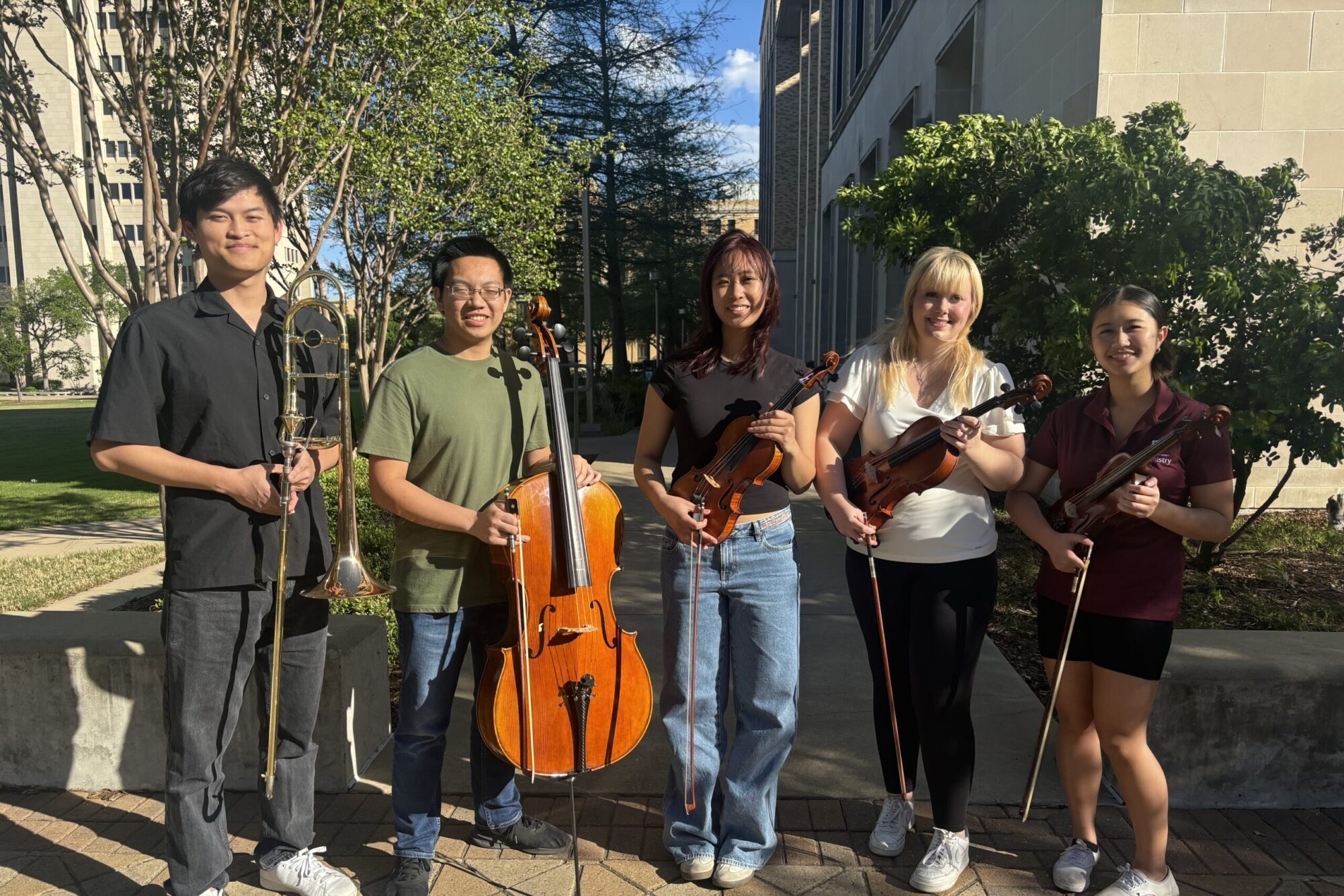 A photo of five college students posing with their instruments. They are in a Piano and Trombone Ensemble.