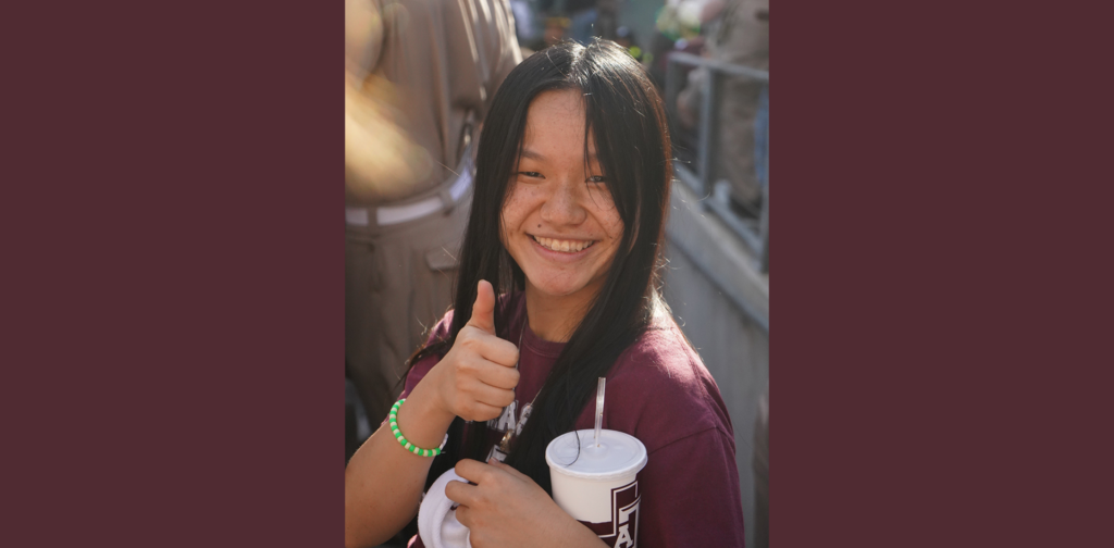 A college student gives the thumbs-up gesture.