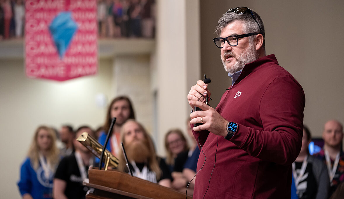 A university professor addresses a crowd of students at a 48-hour game jam.