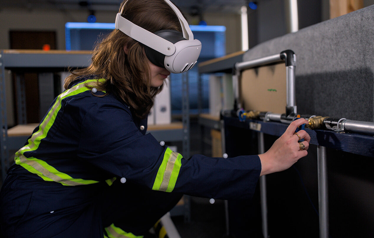 A student wears an augmented reality headset device while exploring a simulated environment.