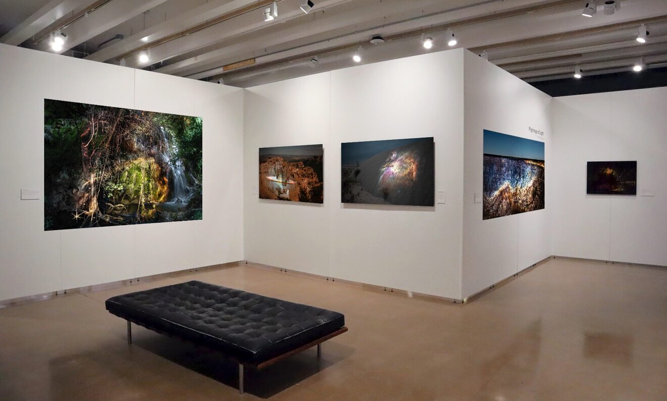 An art gallery is shown with images on the walls that juxtapose space and earthly imagery.