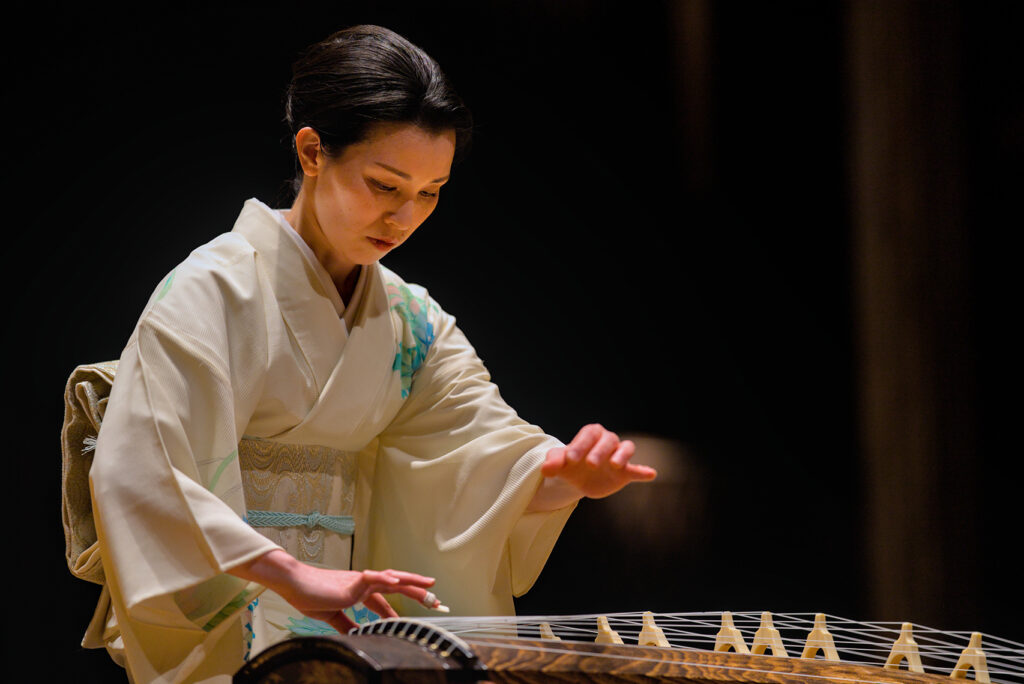 An artist using a Japanese string instrument performs.