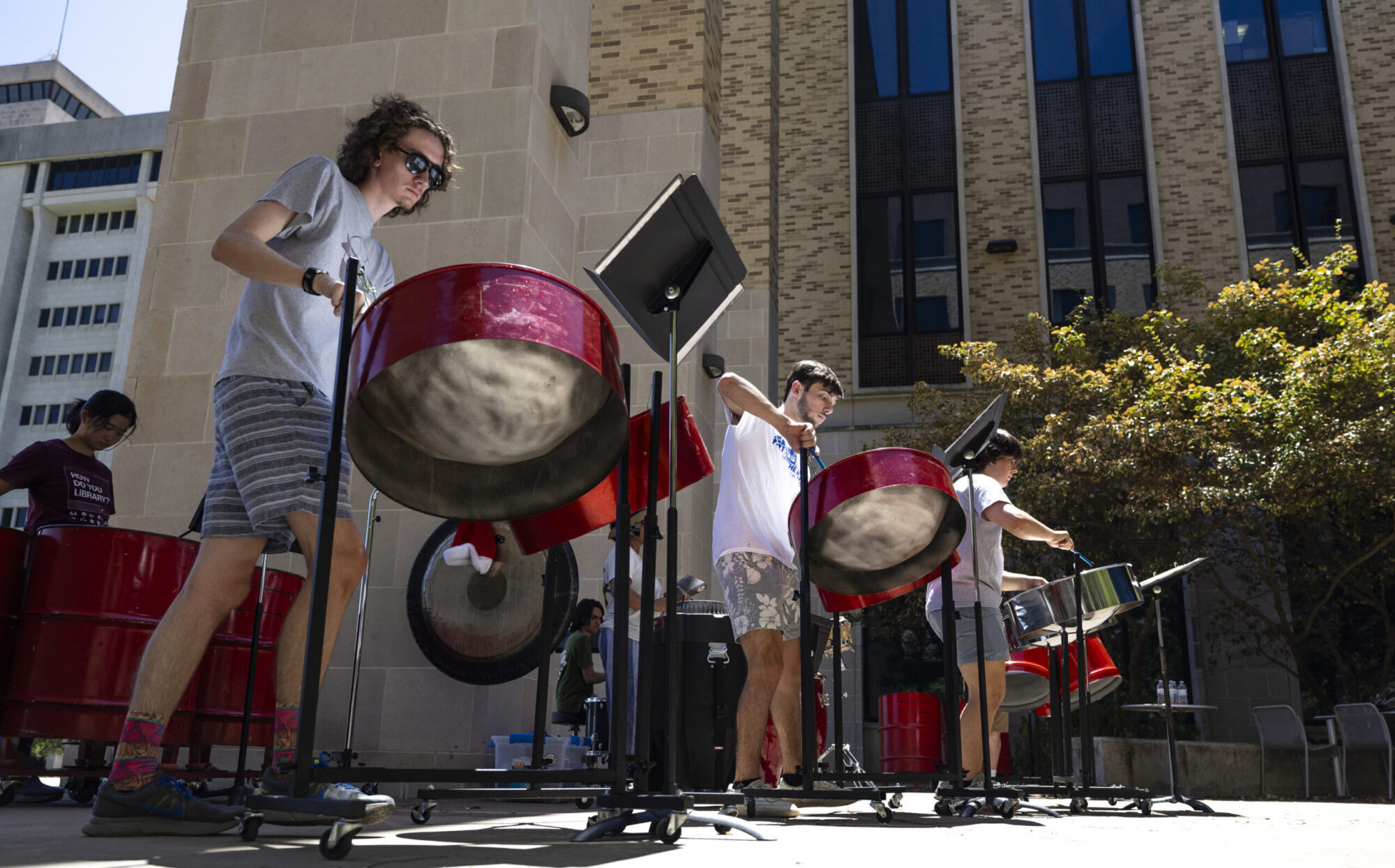 A steel pan ensemble performs in an outdoor setting.