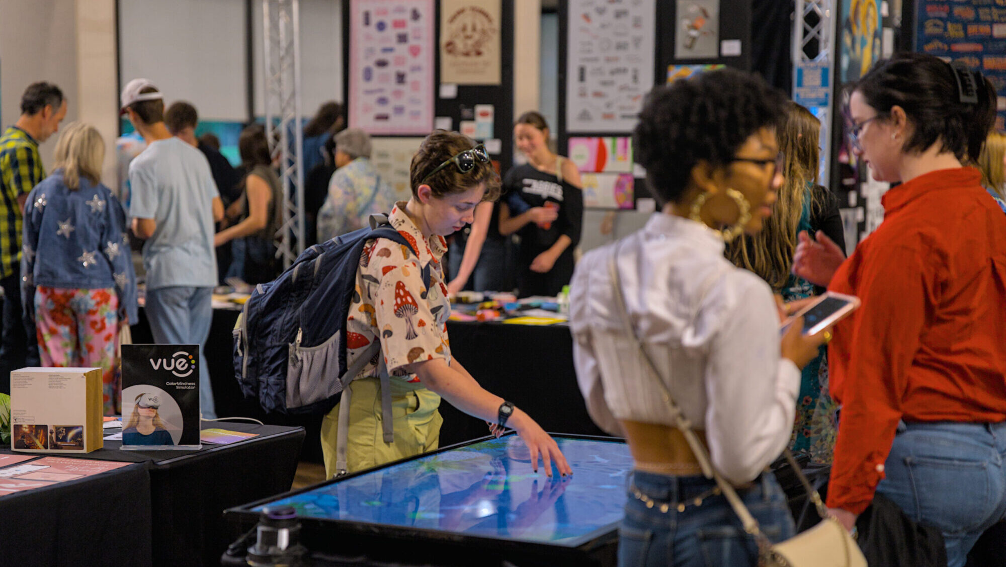 A student interacting with a table-sized touch screen at the exhibition portion of Viz-A-GoGo 2025.