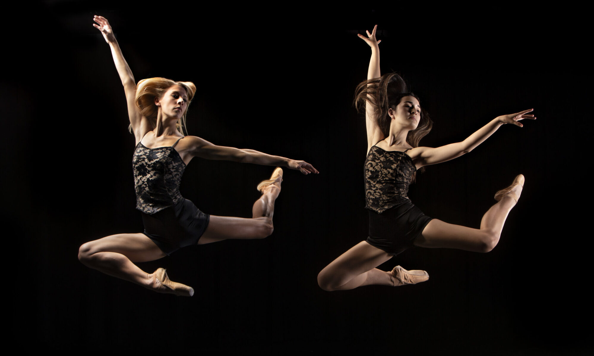 Two dancers are shown in midair.