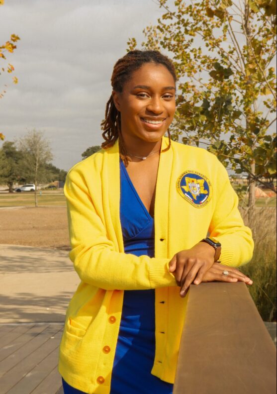 A college student smiles as she poses for a picture.