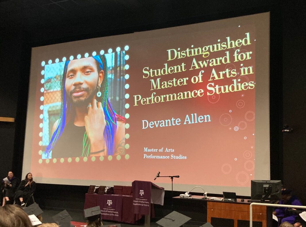 A master's degree graduate is shown on a screen during a graduation event.