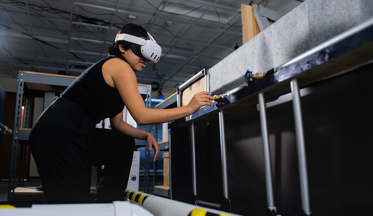 A student wears an augmented reality headset device as she explores a simulated environment.
