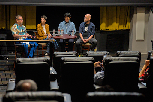 College professors discuss film onstage at a movie theater.