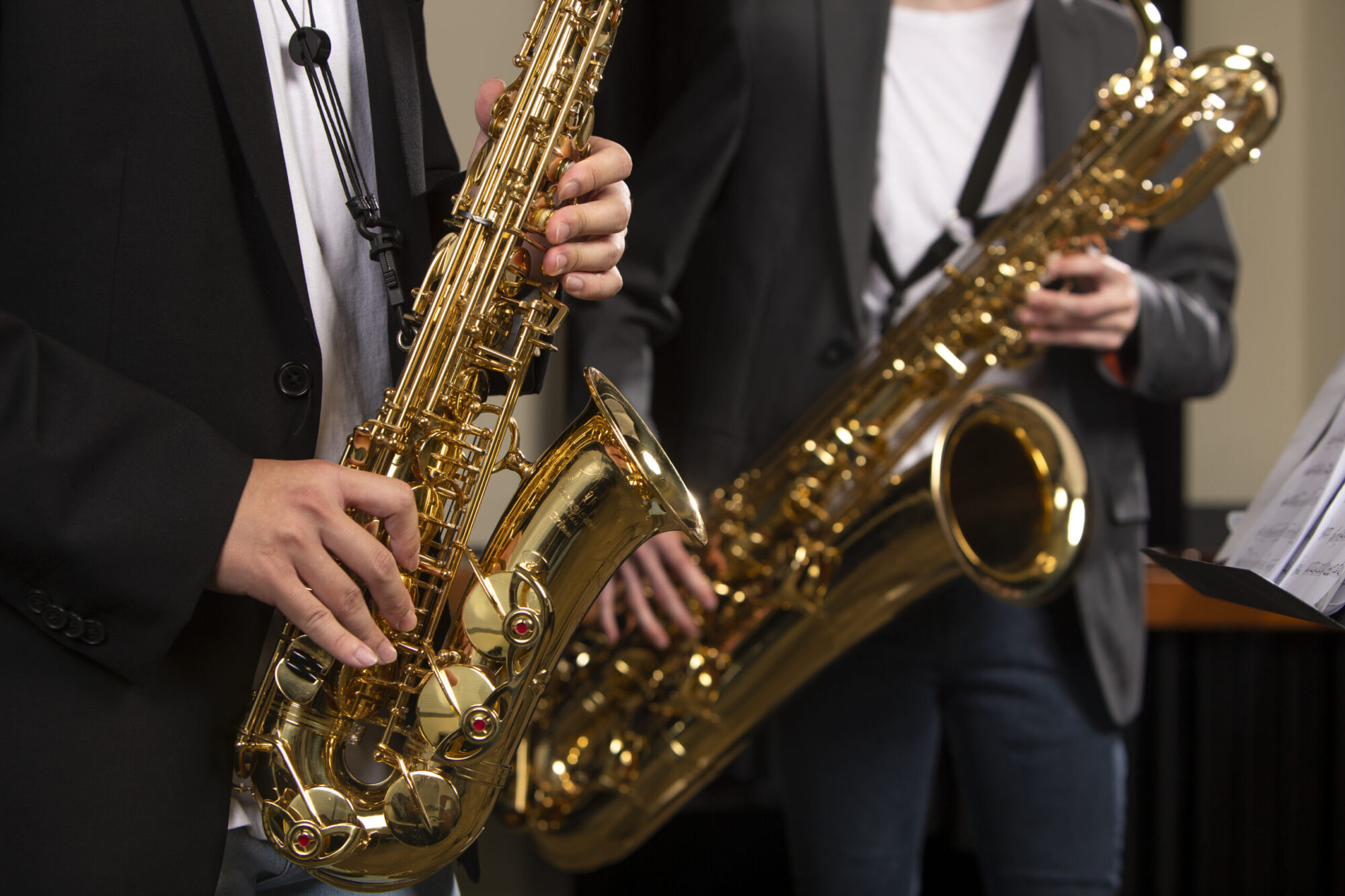 A closeup of two saxophone players performing.