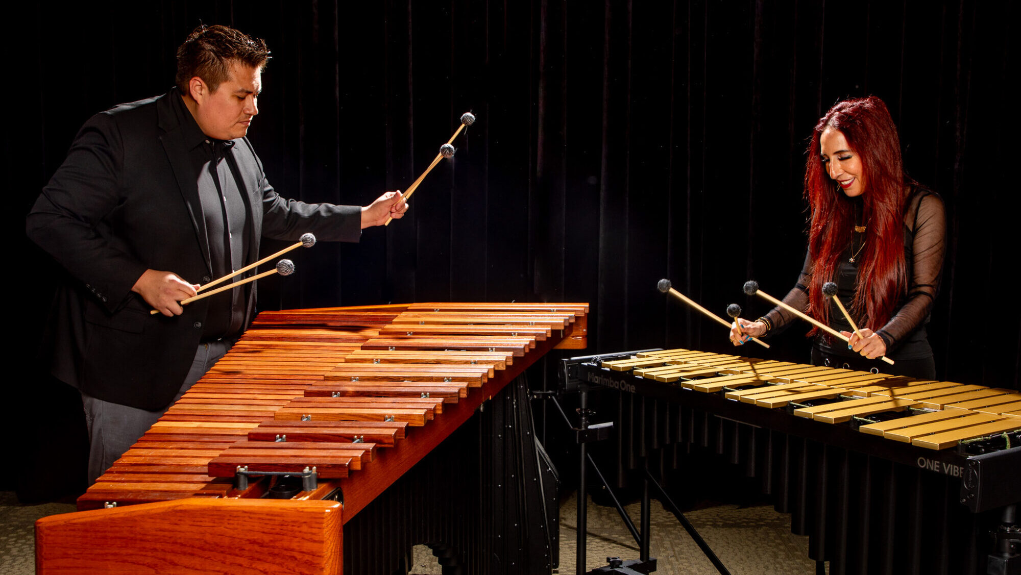 Two music professors facing each other perform marimba music.