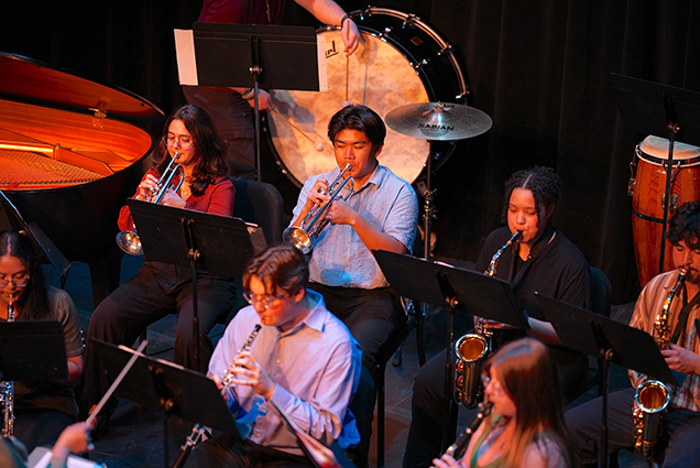 College students play different instruments during an ensemble concert.