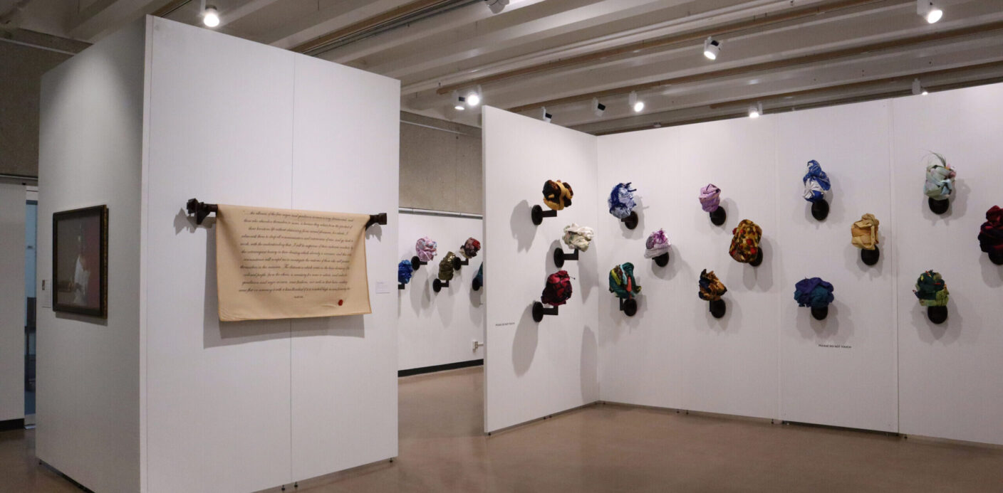 Tignon's and a scroll are on display in an art gallery.