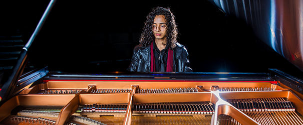 A college student performs on a piano.