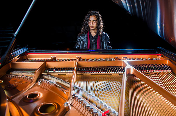 A college student performs on a piano.