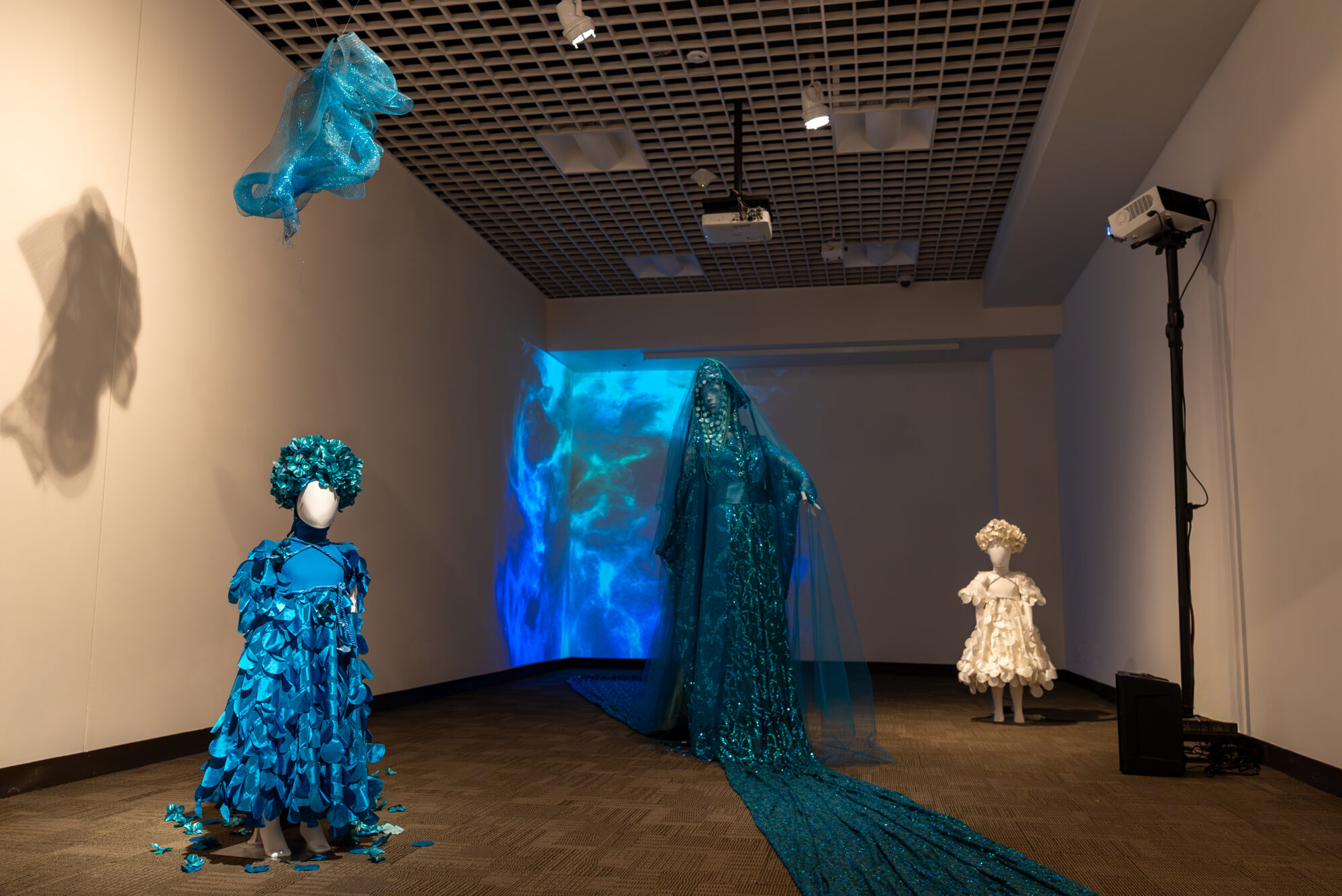 Three mannequins are standing in a university art gallery.