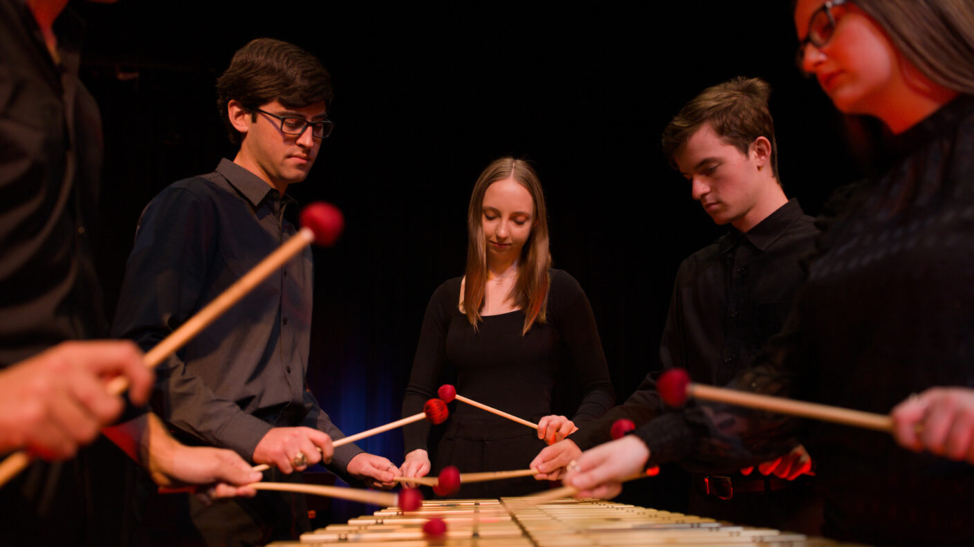 Four university students play a marimba.