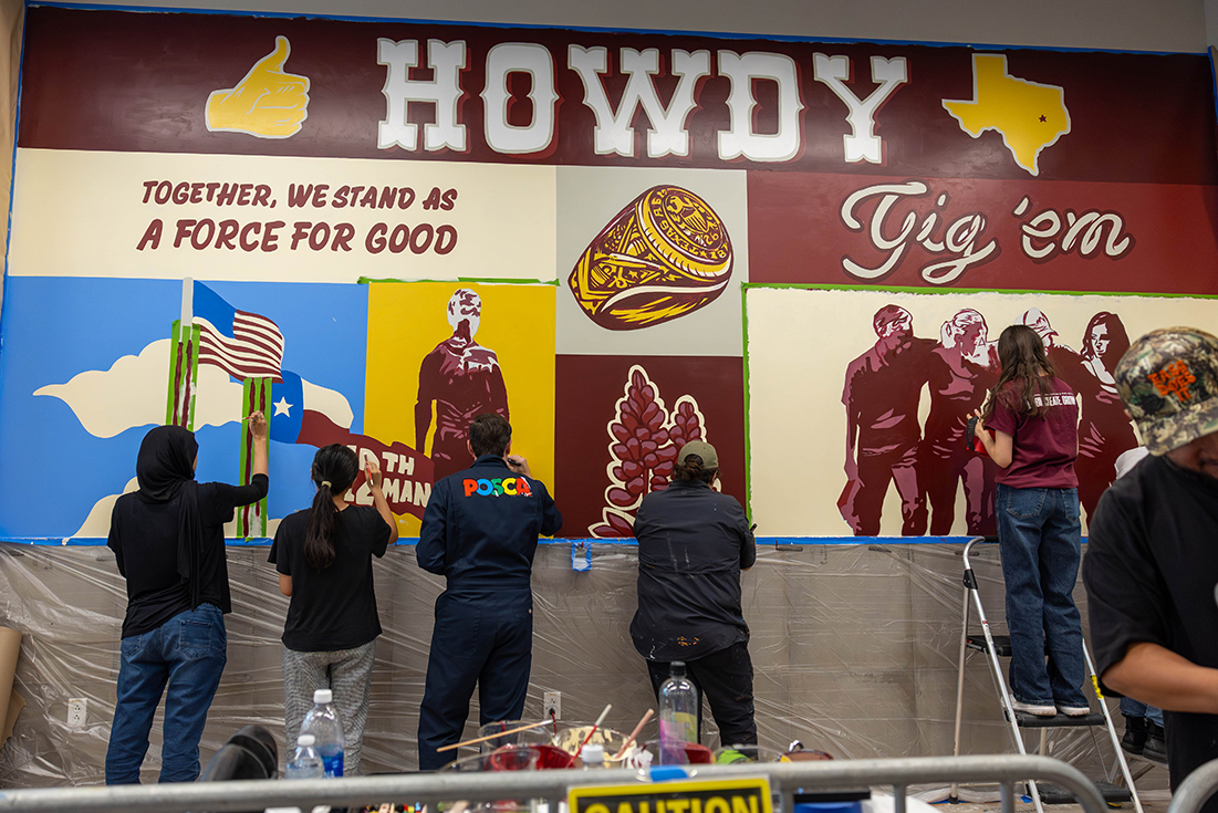 College students paint a mural at Texas A&M University.
