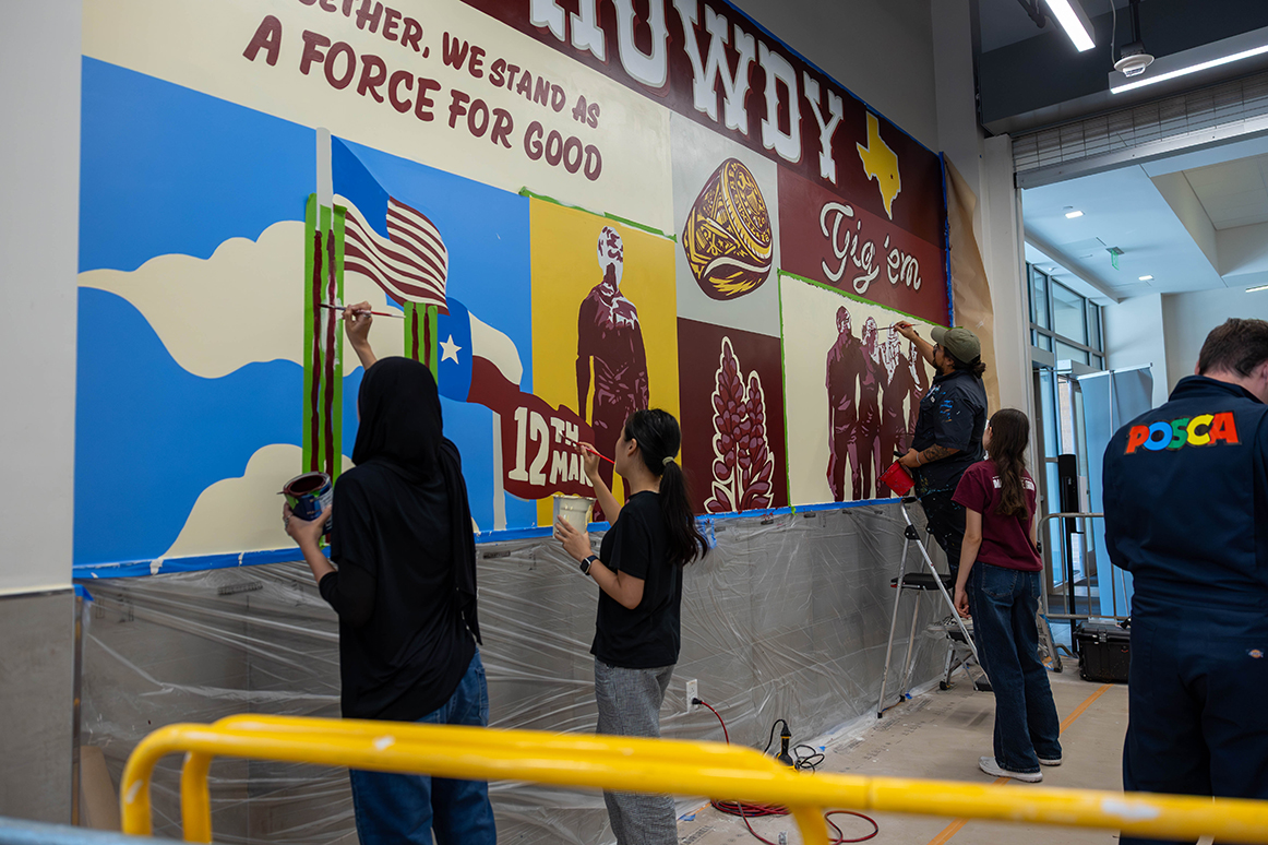 College students paint a mural at Texas A&M University.