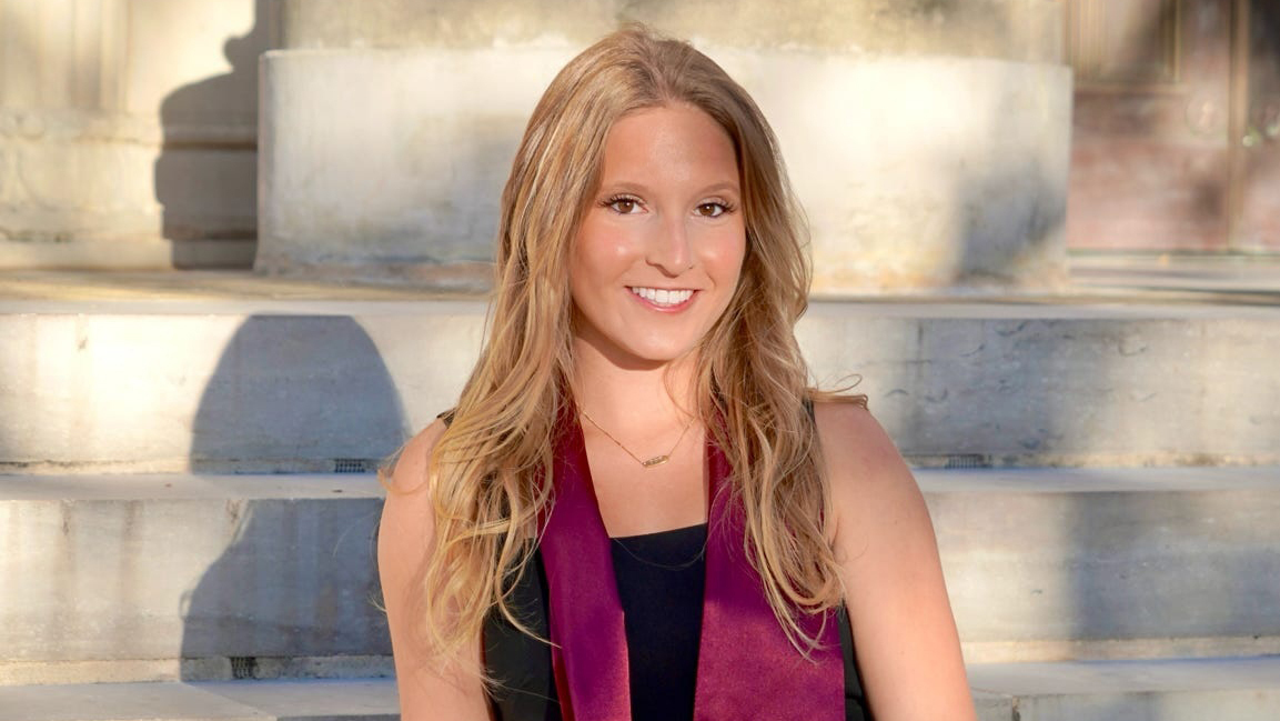 A university student poses for a graduation headshot photo.
