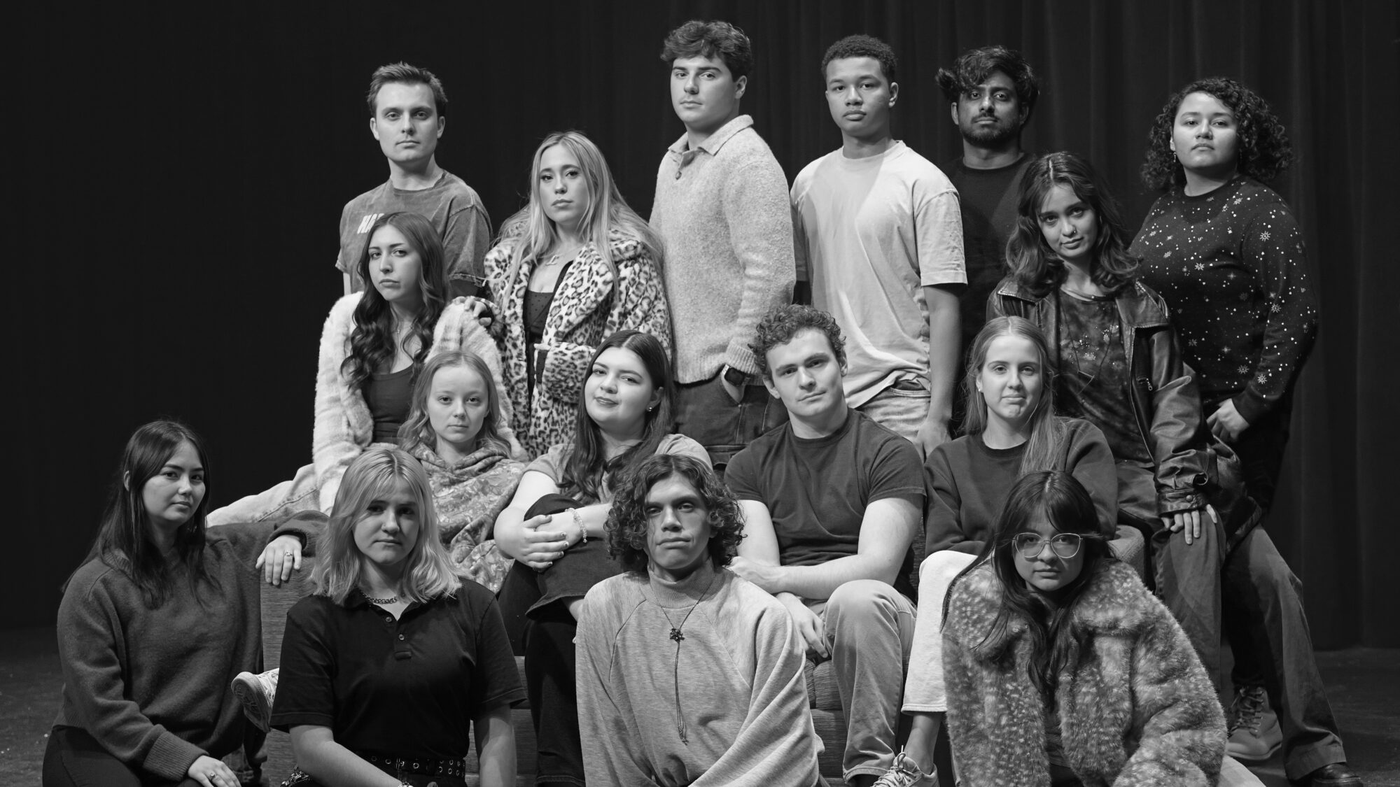 16 university students stand and some sit for a posed photograph.