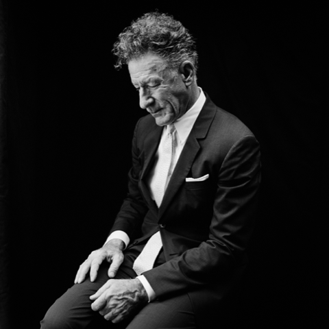 Singer-songwriter Lyle Lovett is shown wearing a dark suit.