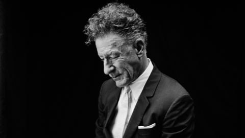 Singer-songwriter Lyle Lovett is pictured wearing a dark suit.